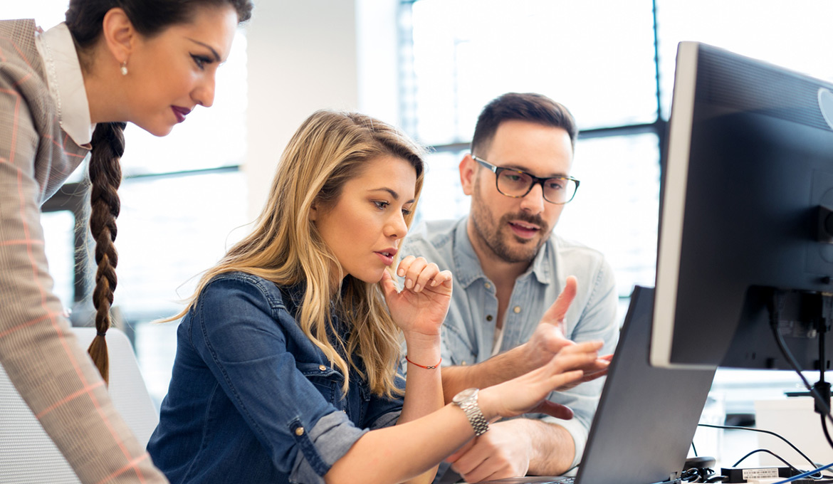 Two women and a man are collaborating together using enterprise software.