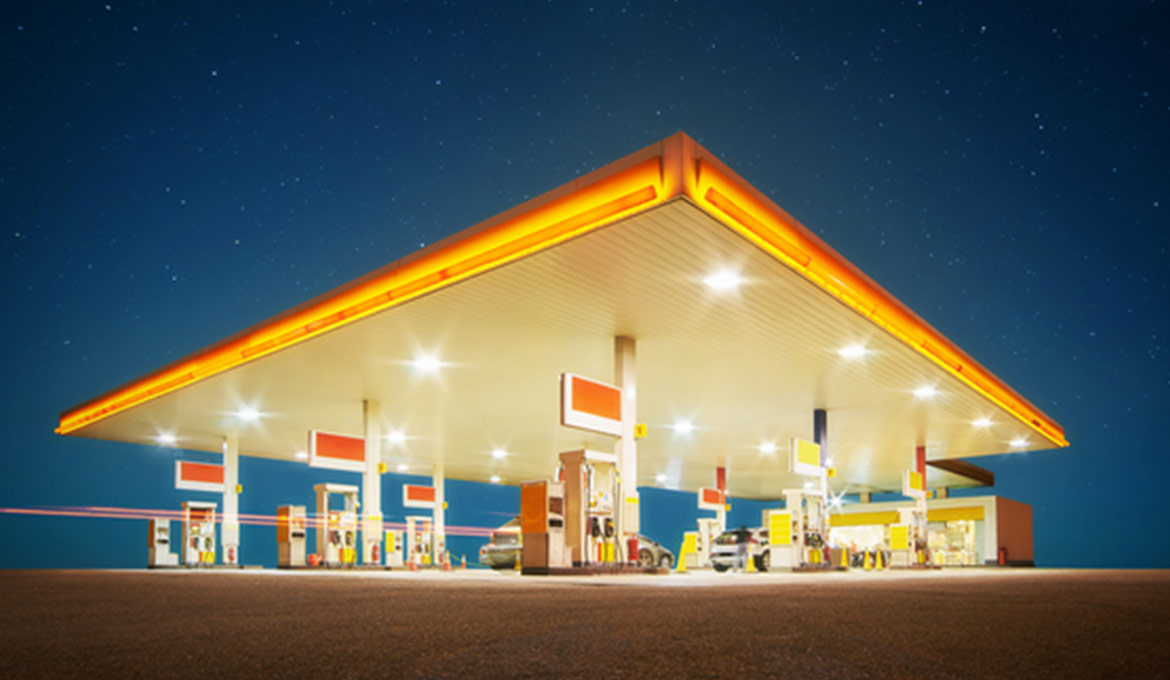 Glowing convenience store forecourt at night against a starry sky.