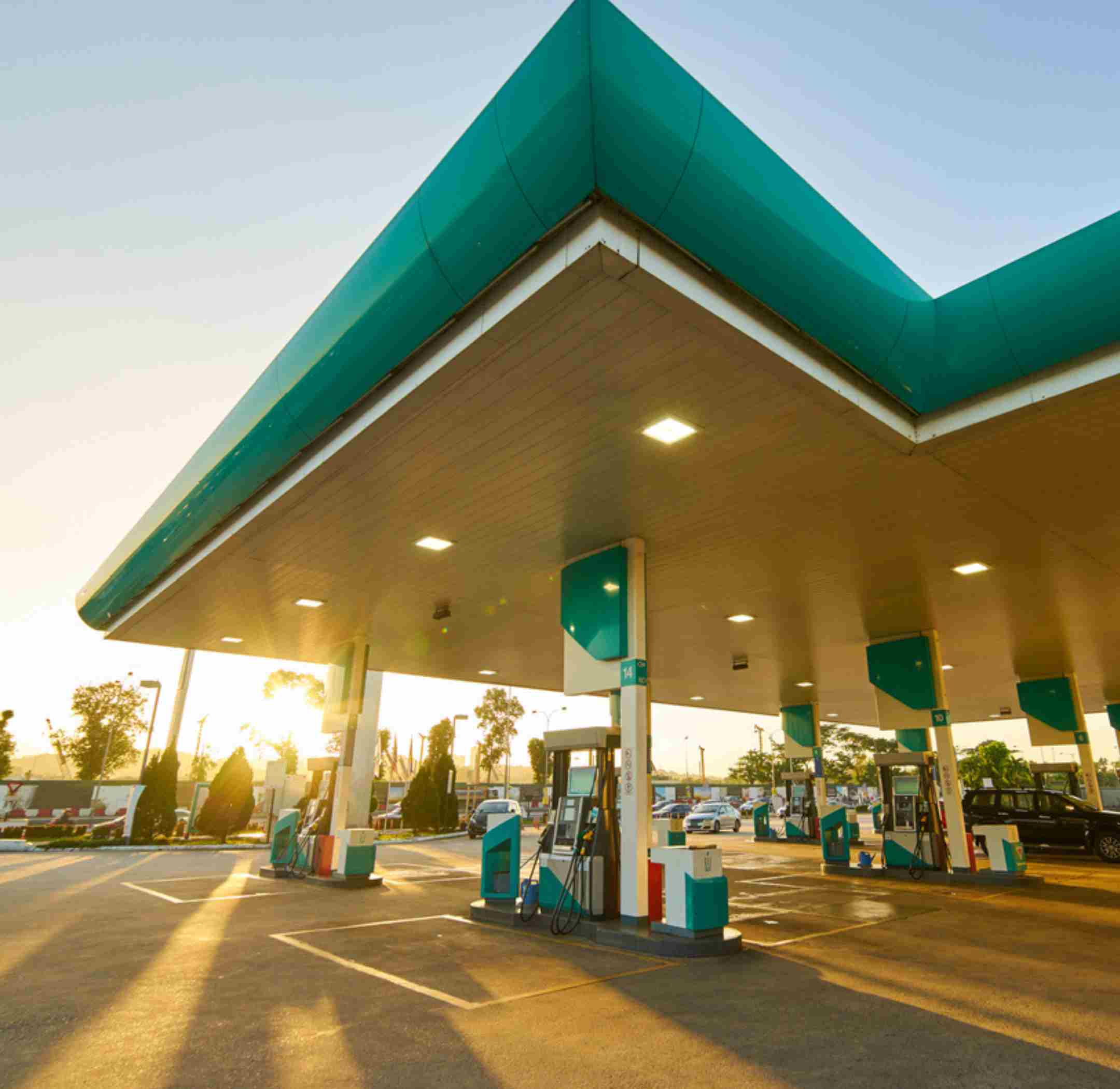 Large green and white petrol station and forecourt.