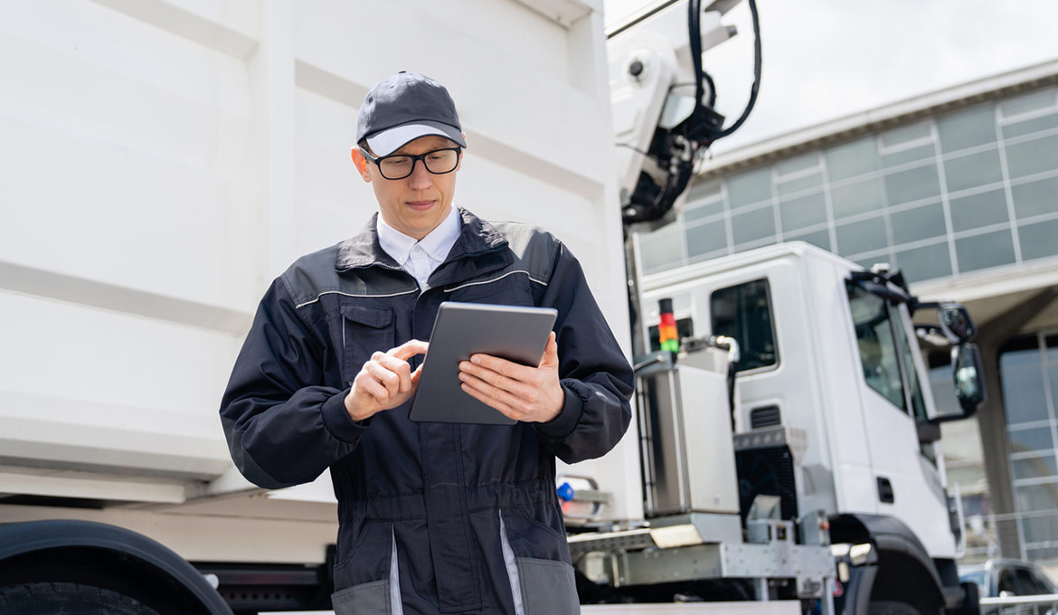 Maintenance worker logging details on a tablet.