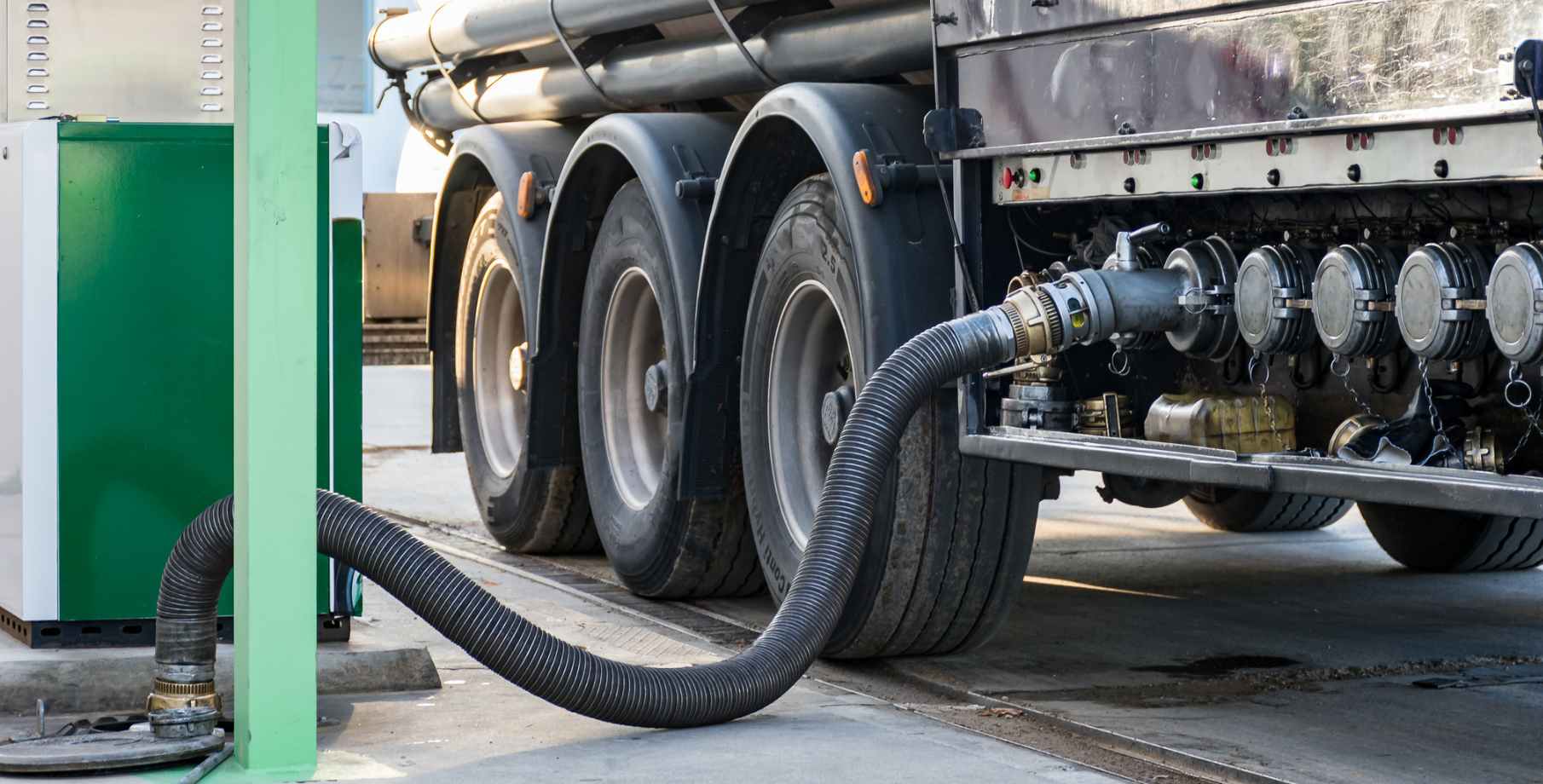 Large tanker truck delivery fuel to an underground storage tank.