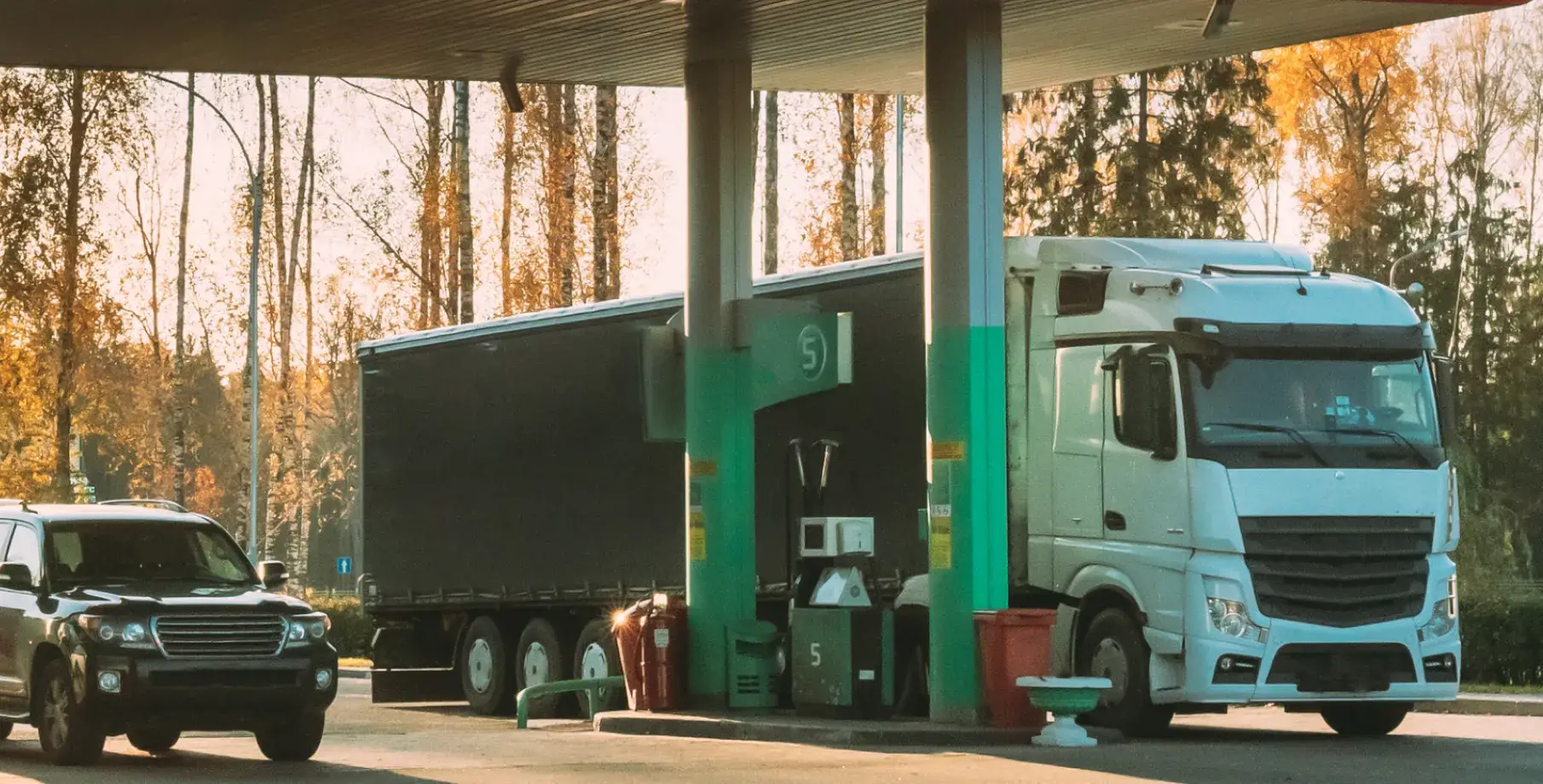 Large truck fueling up at a petrol station.