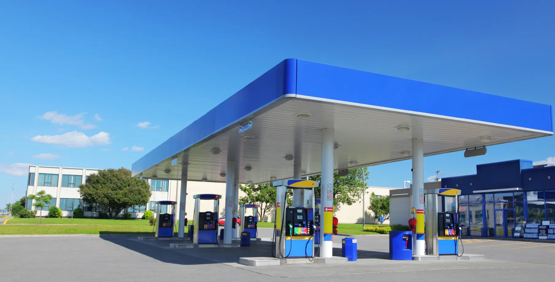 Large blue and white convenience store and forecourt.