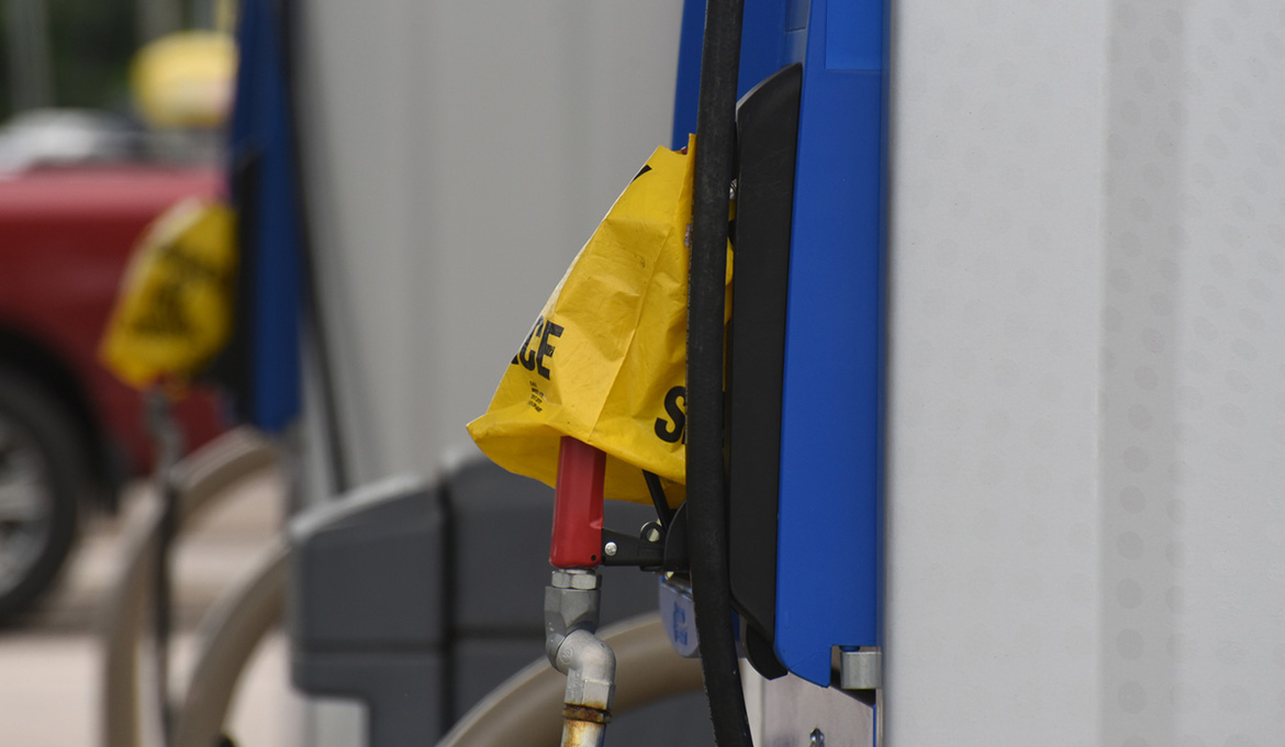 Pumps at a gas station are covered with plastic bags due to fuel supply chain disruption.