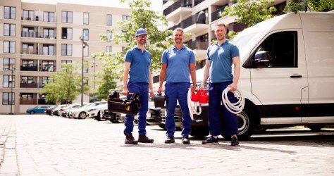 Illustrative field-service team beside equipment and a service vehicle